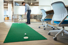 Load image into Gallery viewer, Man practicing golf on PUTT-A-BOUT 3x11 Putting Mat in office conference room
