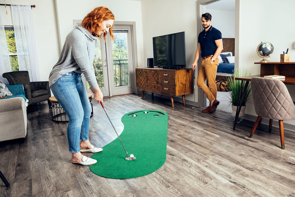 Couple playing on PUTT-A-BOUT Par 3 Putting Green in home living room