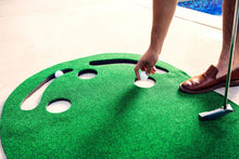 Load image into Gallery viewer, Man reaching down to pick up golf ball from hole of PUTT-A-BOUT Par 3 Putting Green
